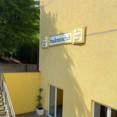 Gelbes Gebäude mit Schild 'Studentenclub' im Studentenwohnheim Hildebrandstraße Dresden