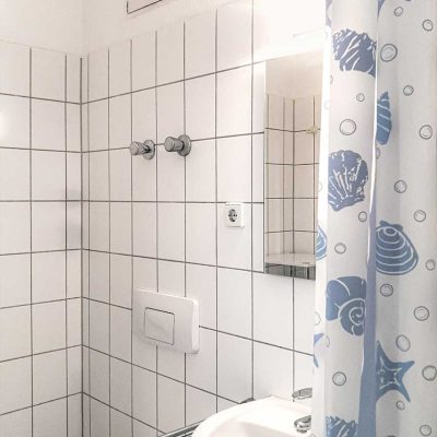 Kompaktes Bad mit Duschkabine, blauem Duschvorhang und Waschbecken im Studentenwohnheim Hildebrandstrasse Dresden